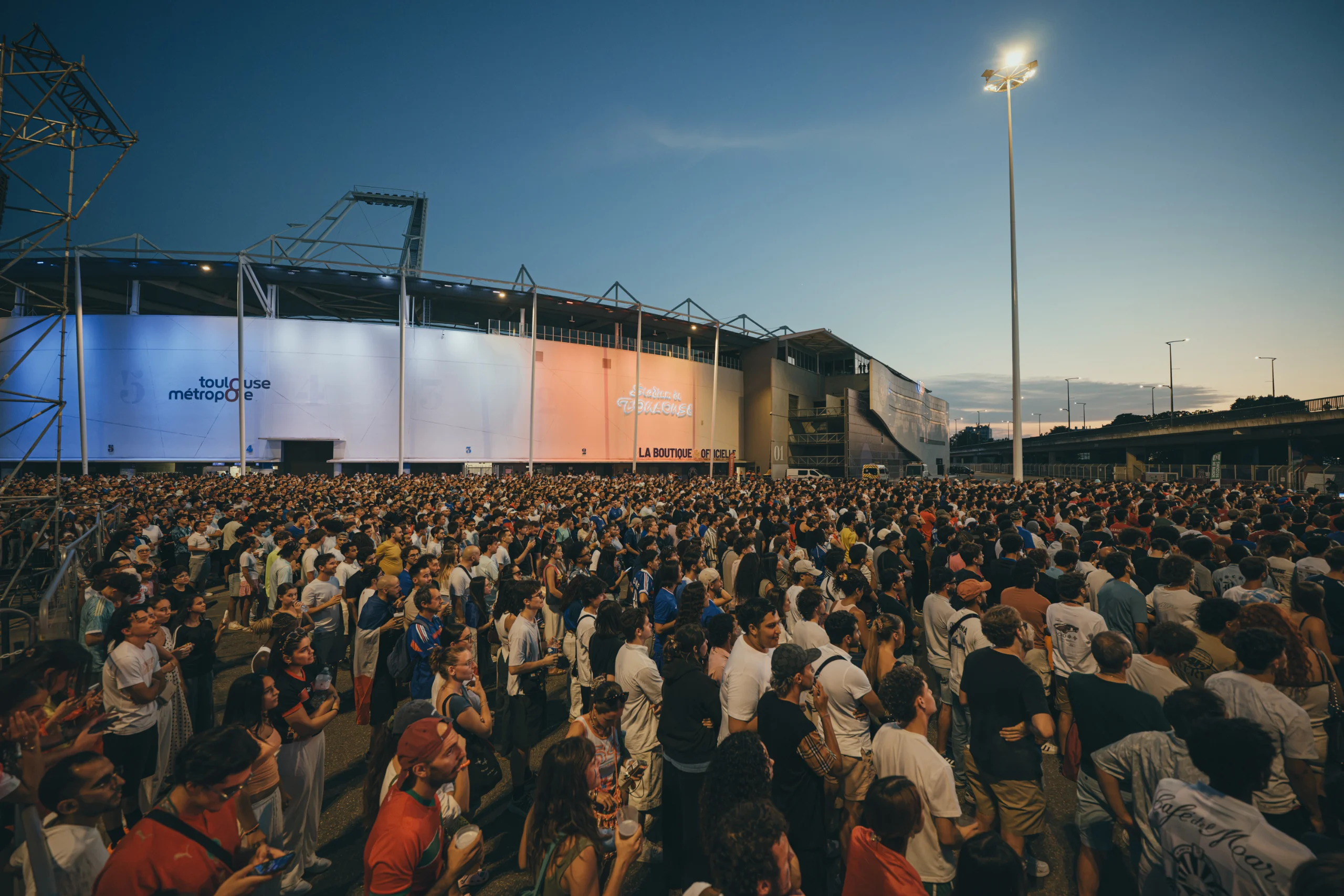 Feu d'artifice et confettis au-dessus de la foule, en soirée au stade